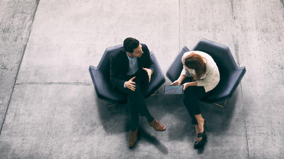 Two people talking to each other on the couch